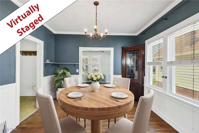 7700 Spring Garden Rd, Parma, OH 44129 - dining space featuring a chandelier, wood finished floors, healthy amount of natural light, wainscoting, and crown molding