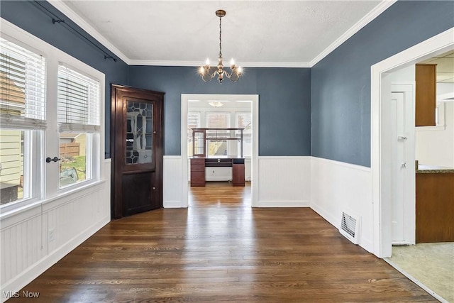 7700 Spring Garden Rd, Parma, OH 44129 - unfurnished dining area with dark wood-style flooring, a chandelier, a wainscoted wall, and ornamental molding
