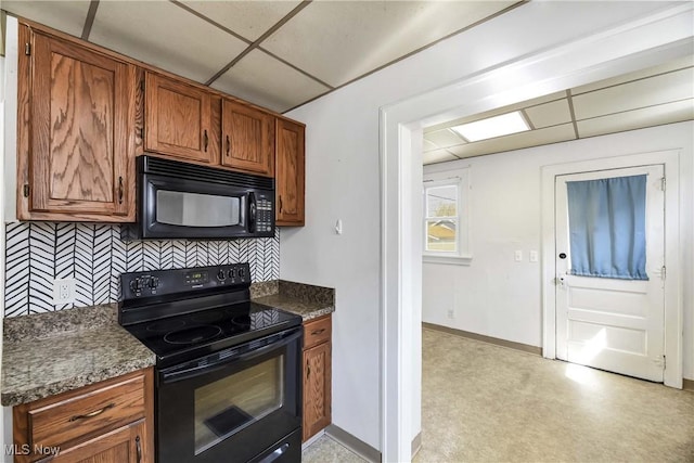 7700 Spring Garden Rd, Parma, OH 44129 - kitchen with black appliances, a paneled ceiling, tasteful backsplash, brown cabinets, and baseboards