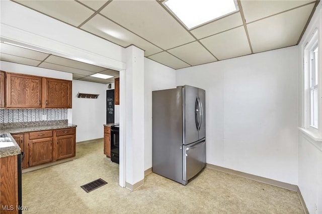 7700 Spring Garden Rd, Parma, OH 44129 - kitchen with freestanding refrigerator, a paneled ceiling, light colored carpet, brown cabinetry, and baseboards