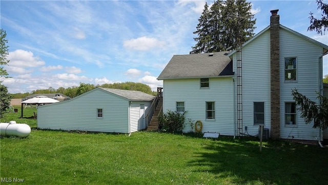 15561 Georgetown St NE, Minerva, OH 44657 - back of house featuring a lawn, a chimney, and roof with shingles