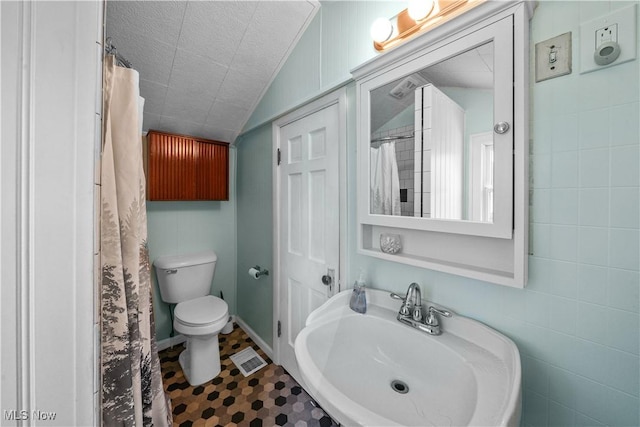 15561 Georgetown St NE, Minerva, OH 44657 - bathroom featuring a sink, toilet, lofted ceiling, and a shower with shower curtain