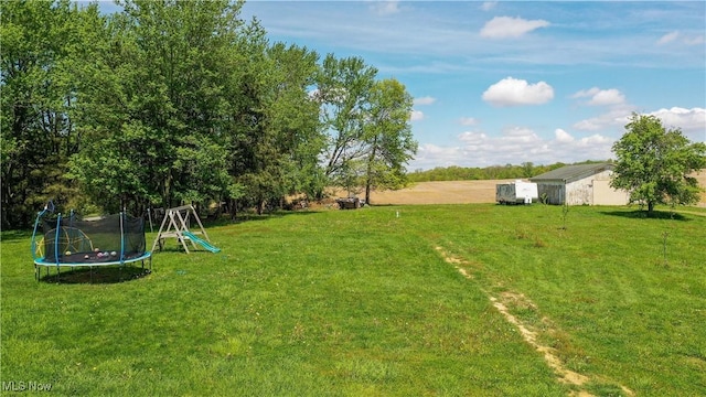 15561 Georgetown St NE, Minerva, OH 44657 - view of grassy yard with a trampoline and an outbuilding