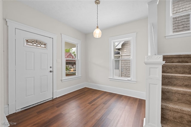 entrance foyer with dark wood-type flooring, baseboards, and stairs