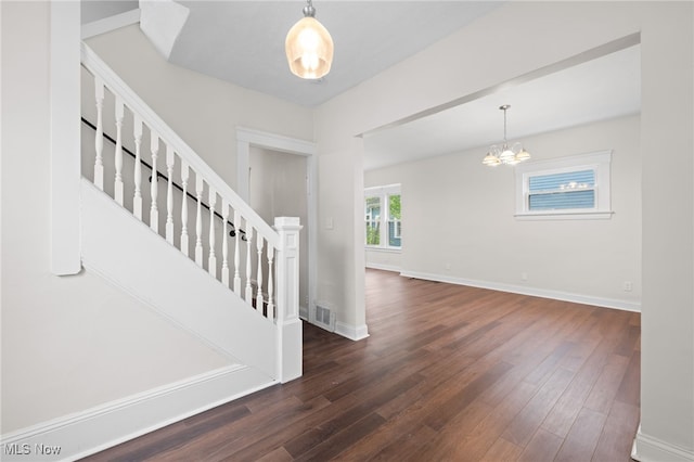 entrance foyer with wood finished floors, stairway, a chandelier, and baseboards