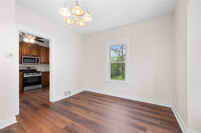 unfurnished dining area with dark wood-type flooring, a chandelier, and baseboards
