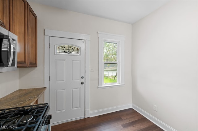 entryway featuring dark wood-type flooring and baseboards