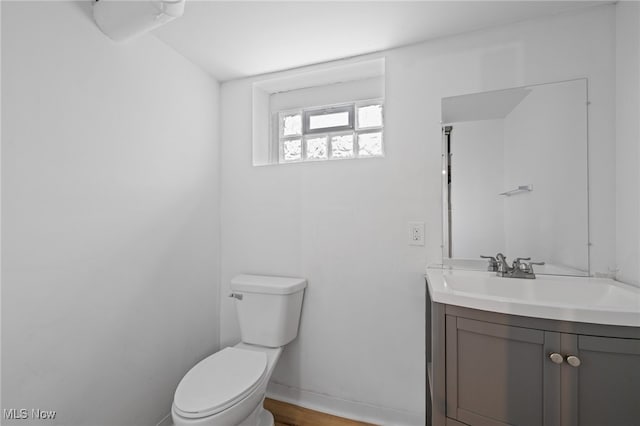 bathroom with vanity, toilet, and baseboards