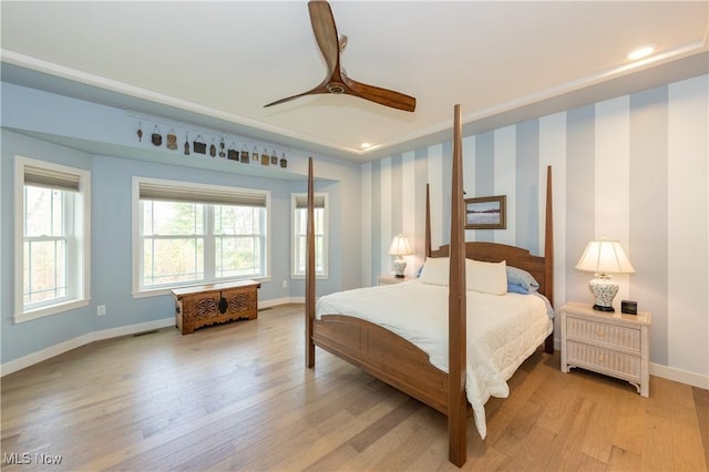 bedroom featuring baseboards, light wood-style floors, and a ceiling fan