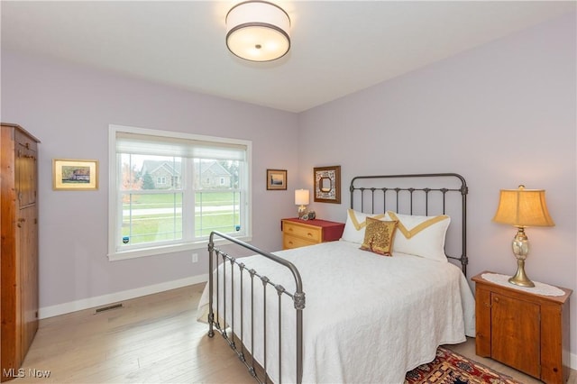 bedroom featuring light wood-type flooring and baseboards