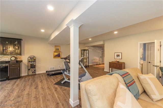 workout room featuring wood finished floors, recessed lighting, baseboards, and decorative columns