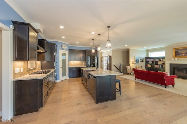 kitchen featuring ornamental molding, open floor plan, freestanding refrigerator, backsplash, and a sink