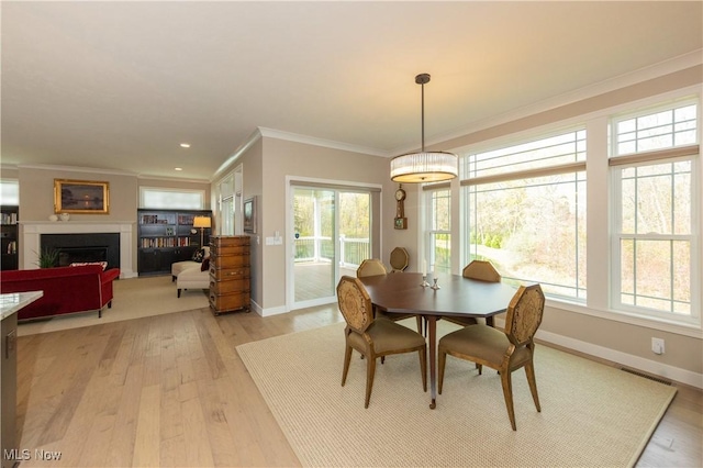 dining room with ornamental molding, light wood-type flooring, baseboards, a fireplace, and recessed lighting