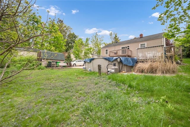 rear view of house with a wooden deck and a yard