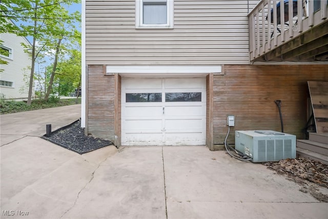 garage featuring central air condition unit and concrete driveway