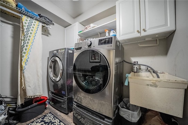24660 Sittingbourne Ln, Beachwood, OH 44122 - laundry room featuring cabinet space, washer and dryer, and wood finished floors