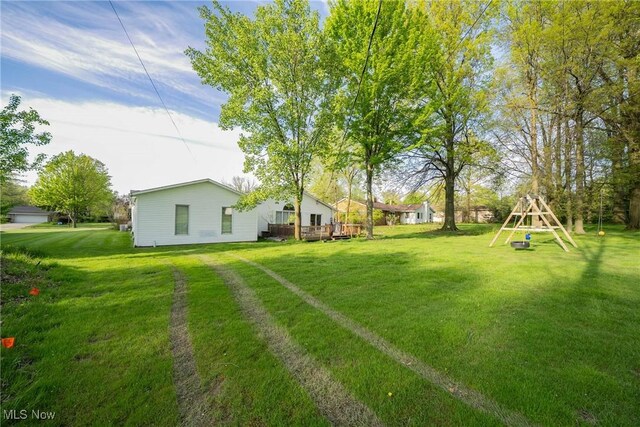 24660 Sittingbourne Ln, Beachwood, OH 44122 - view of grassy yard featuring a wooden deck and a playground