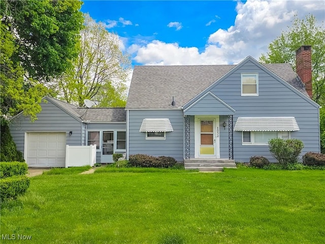 view of front of property with an attached garage, a chimney, a front yard, and roof with shingles