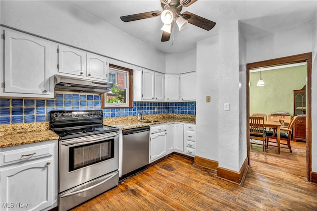 kitchen with stainless steel appliances, under cabinet range hood, tasteful backsplash, a ceiling fan, and white cabinetry