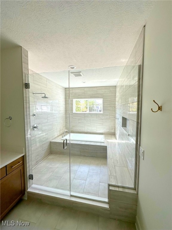 2702 Rocky Ridge Dr, Westlake, OH 44145 - bathroom featuring tile patterned floors, a stall shower, a textured ceiling, and tiled bath