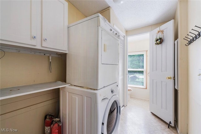 9493 State Route 9, Hanoverton, OH 44423 - clothes washing area featuring estacked washer and dryer, cabinet space, light flooring, and a textured ceiling