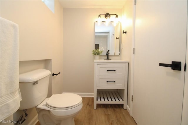 1674 Yolanda Dr, Austintown, OH 44511 - half bathroom featuring wood finished floors, toilet, vanity, and baseboards