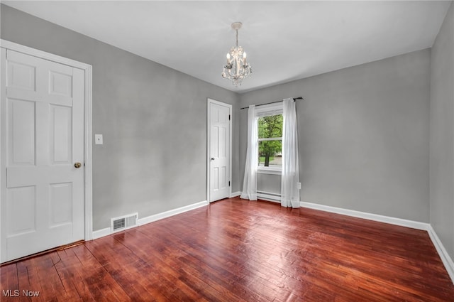 unfurnished room with a chandelier, baseboards, wood finished floors, and baseboard heating
