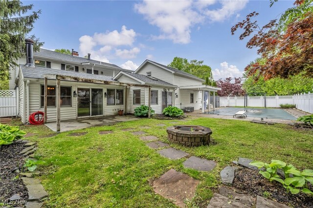 rear view of house featuring a fire pit and a patio