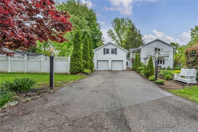 view of front facade with fence, a garage, and driveway