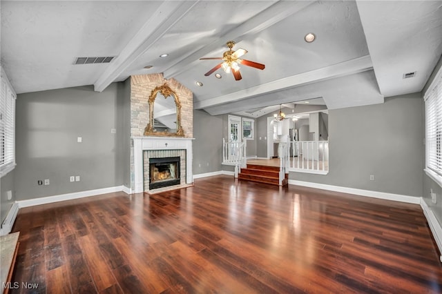 unfurnished living room featuring ceiling fan, stairway, healthy amount of natural light, and a brick fireplace