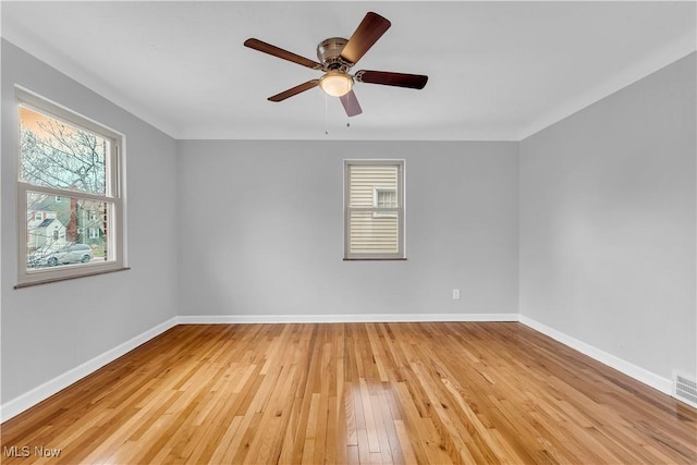 empty room featuring light wood-style floors, baseboards, and ceiling fan