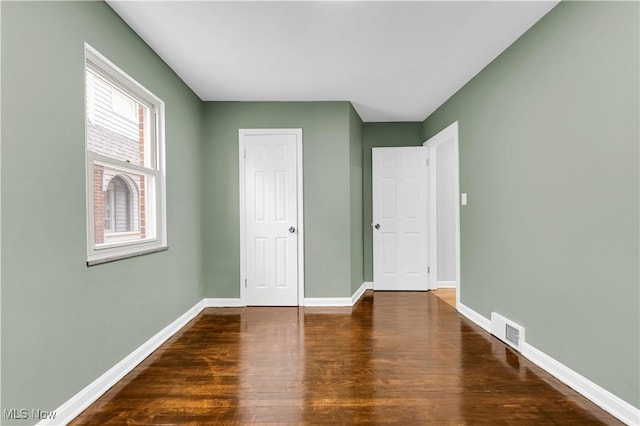 unfurnished bedroom with wood finished floors and baseboards