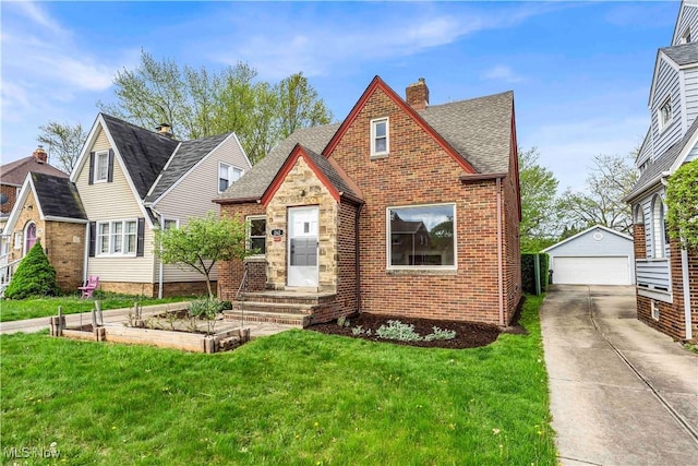 english style home featuring an outbuilding, a front lawn, a garage, brick siding, and a chimney