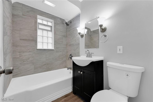 bathroom with toilet, vanity, bathtub / shower combination, and wood finished floors