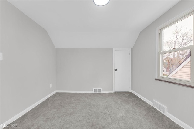 bonus room featuring lofted ceiling, carpet, healthy amount of natural light, and baseboards