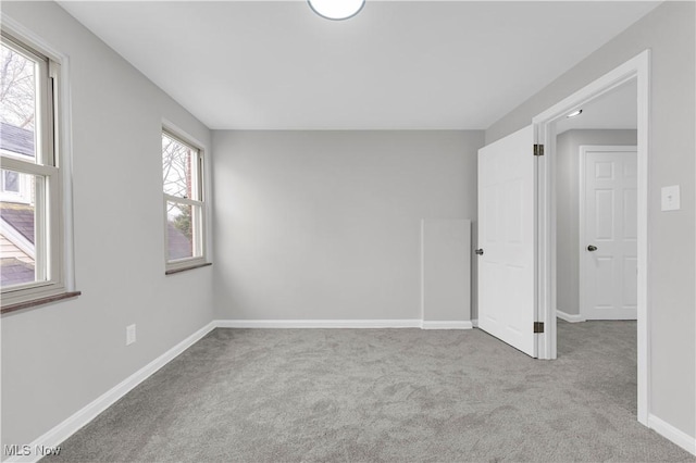 carpeted empty room with baseboards