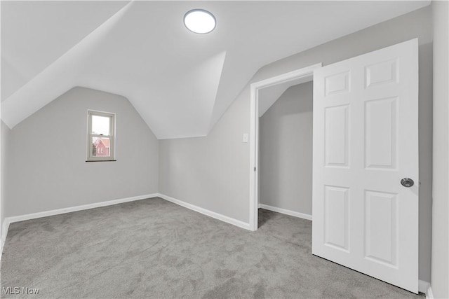additional living space with carpet, vaulted ceiling, and baseboards