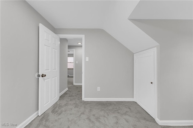 additional living space with carpet floors, vaulted ceiling, and baseboards