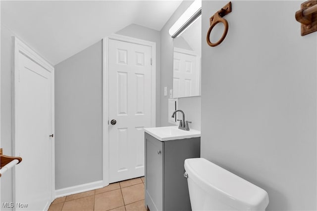 half bath featuring vaulted ceiling, toilet, tile patterned flooring, vanity, and baseboards