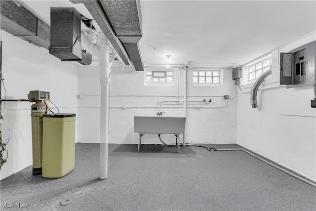 below grade area featuring electric panel, a water softener system, and a sink