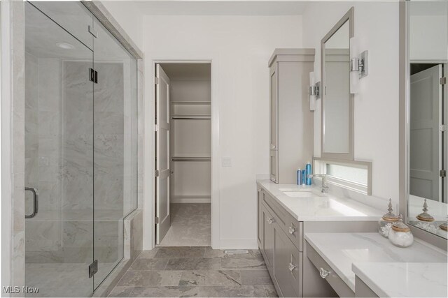 full bath featuring a stall shower, vanity, and a spacious closet