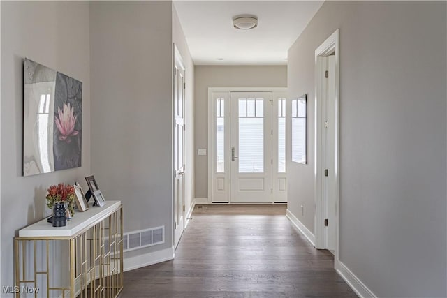 foyer entrance with dark wood-type flooring and baseboards