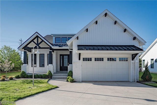 modern farmhouse style home with a standing seam roof, concrete driveway, a front lawn, an attached garage, and brick siding