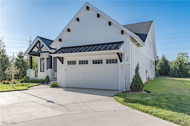 modern farmhouse style home with concrete driveway, a standing seam roof, a front yard, metal roof, and a garage