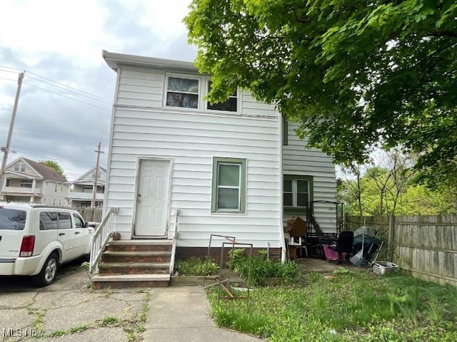 rear view of house with fence and entry steps