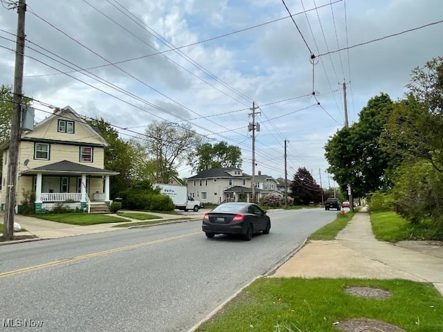 view of asphalt street with sidewalks, a residential view, and curbs