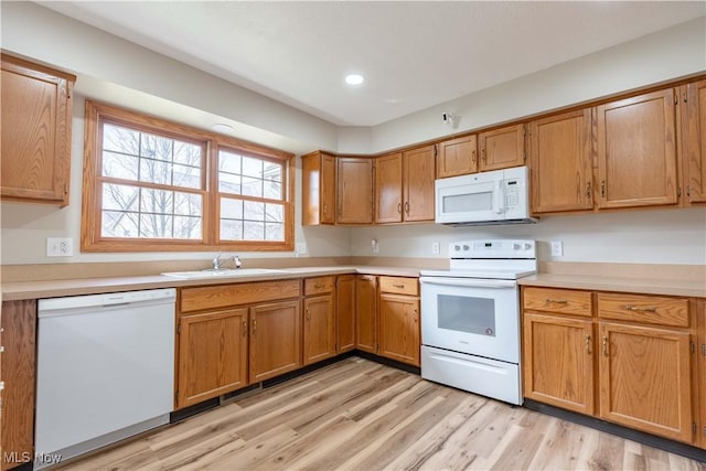 847 Beverly Ave, Canal Fulton, OH 44614 - kitchen with white appliances, a sink, light countertops, light wood-style flooring, and brown cabinets
