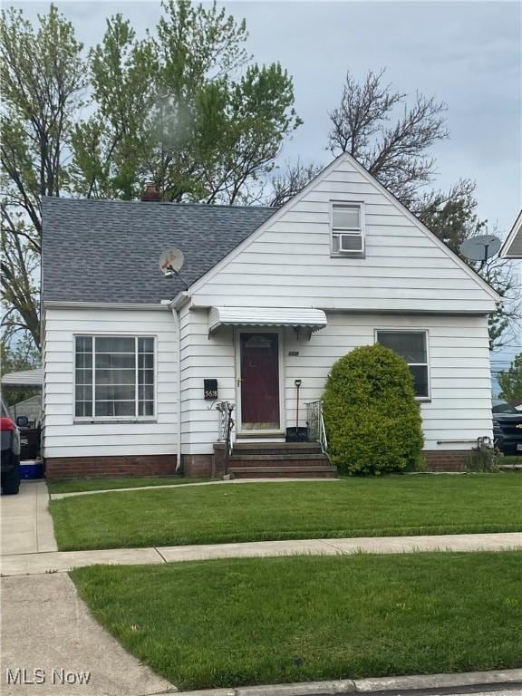 bungalow-style house with a front yard and roof with shingles