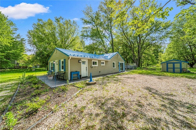 6329 Green Rd, North Kingsville, OH 44004 - rear view of property featuring metal roof, a patio, a yard, and view of scattered trees