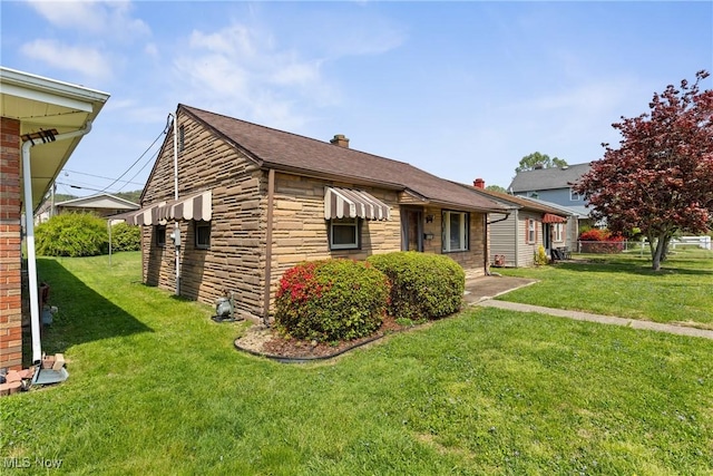 view of side of property with stone siding, a lawn, a chimney, and roof with shingles
